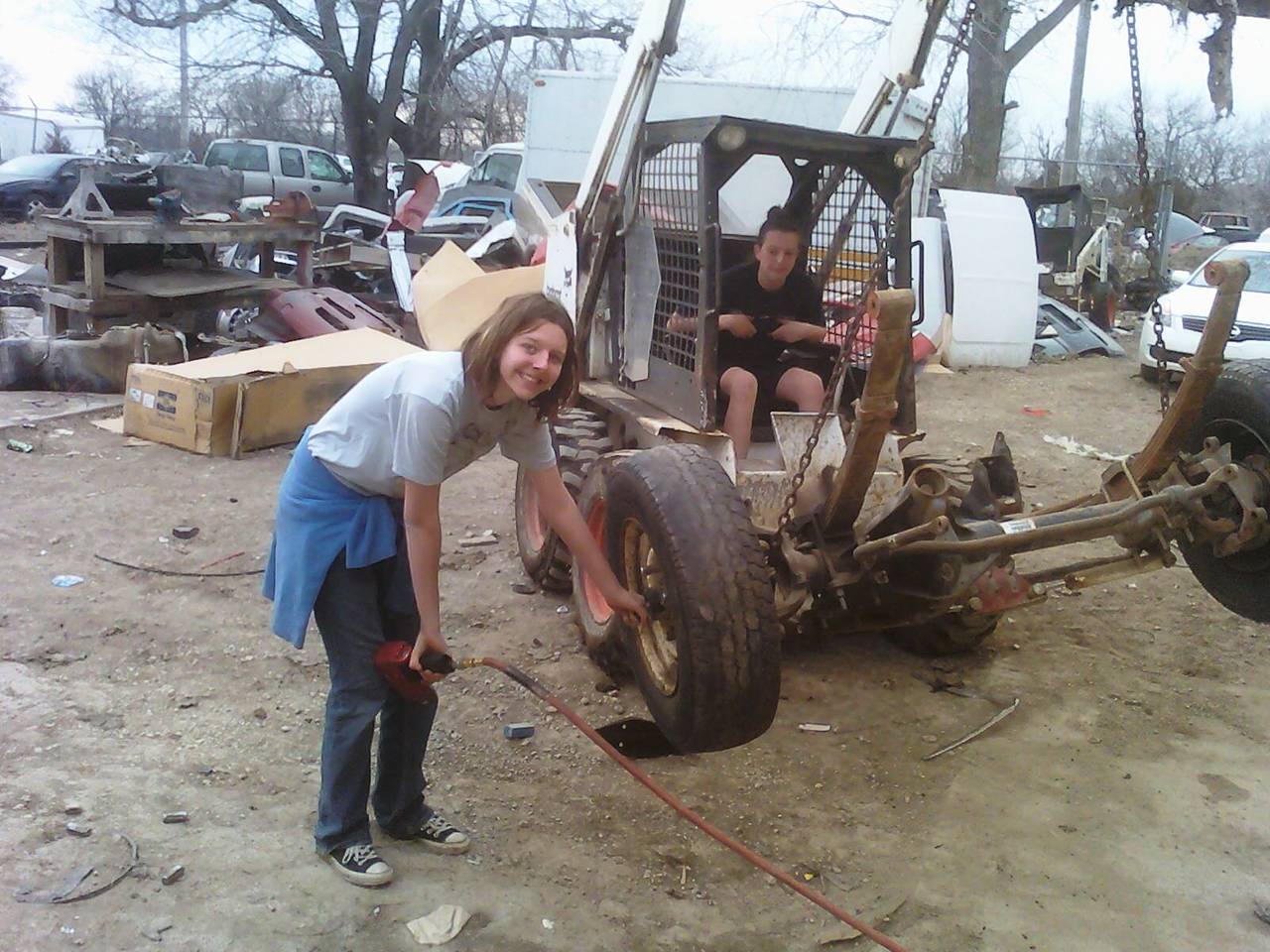 Lauryn in the Bobcat and Andi putting the wheels back on.