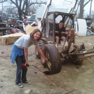 Lauryn in the Bobcat and Andi putting the wheels back on.