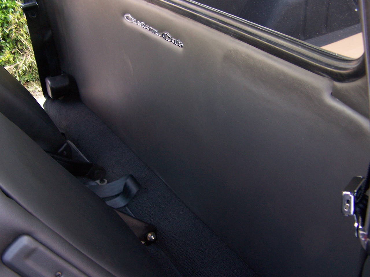 Behind the seats back wall