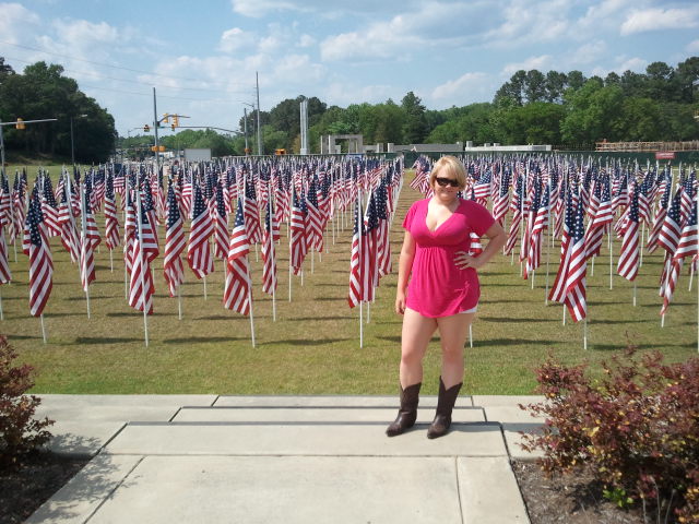 Girlfriend standing in front of field of American Flags